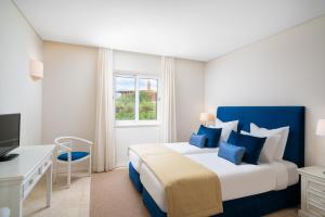 a hotel room with a bed and a window at Monte Santo Resort in Carvoeiro