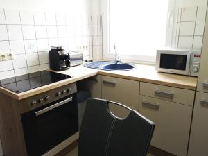 a kitchen with a stove and a microwave and a chair at Sommerhaus Verchen in Verchen