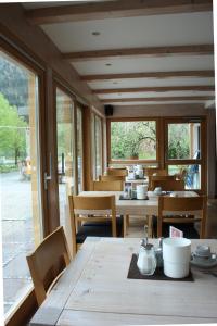 a dining room with a table and chairs and windows at Das Posch Hotel in Oberammergau