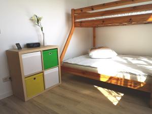 a bedroom with a bunk bed and a dresser with a bed sqor at Sommerhaus Verchen in Verchen