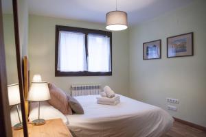 a bedroom with a bed with a lamp and a window at Apartamento Toran in Les