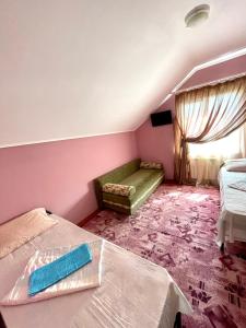 エイスクにあるУ ЗоИ на Мираのベッド2台と緑のソファが備わる客室です。
