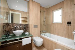 a bathroom with a sink and a toilet and a tub at Monte Santo Resort in Carvoeiro