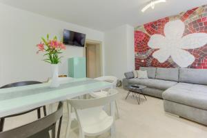 Modern luxury 2-bedroom apt with balcony & patio في قشتيلا: غرفة معيشة مع طاولة وأريكة