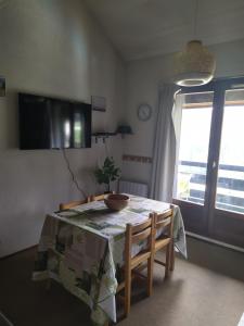 a dining room table with a table cloth and a window at Duplex 3 pièces. Pieds des pistes et balcon! in Gresse-en-Vercors