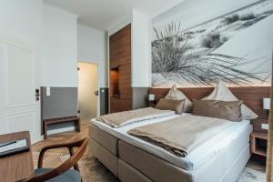 1 dormitorio con cama, mesa y escritorio en Strandhotel Hohenzollern en Borkum