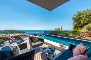 a patio with a couch and chairs and a swimming pool at Skywalker Royal in Dubrovnik