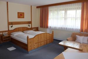 a bedroom with a wooden bed and a couch at Appartementhaus Holmernhof I in Bad Füssing +20 photos