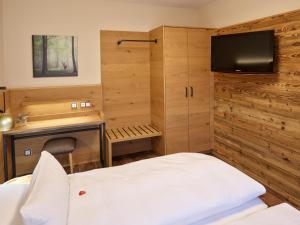 バート・フュッシンクにあるAppartementhaus Holmernhof Iのベッド1台とテレビが備わる小さな客室です。