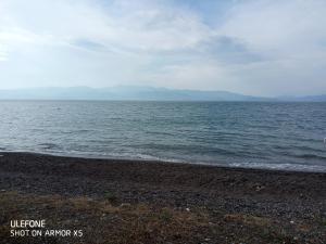 une grande étendue d'eau avec une plage rocheuse dans l'établissement Cozy Maisonette, à Kamena Vourla