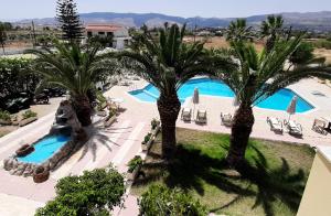 - une vue sur la piscine du complexe bordée de palmiers dans l'établissement Leonidas Hotel & Studios, à Kos
