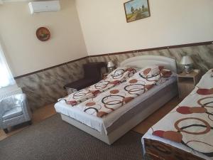 sypialnia z 2 łóżkami i krzesłem w obiekcie Garden Apartmanház 2 w Hajduszoboszlo
