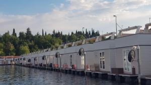 une rangée de maisons sur un quai sur l'eau dans l'établissement Floating Sea House SONČEK, à Portorož