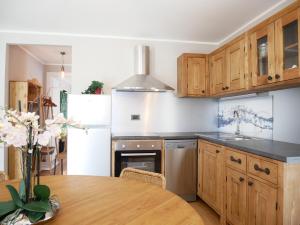a kitchen with wooden cabinets and a table and a refrigerator at Appartamenti Residenza Anderbatt in Gressoney-la-Trinité