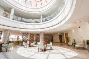 a lobby with tables and chairs and a domed ceiling at Aram Hotel - AlMeshael Exit 18 in Riyadh