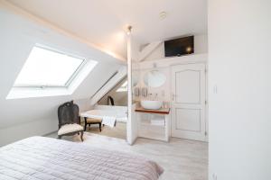 a bedroom with a bed and a bathroom with a sink at Logis - Hotel De La Mairie in Embrun