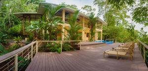 a house with a wooden deck with chairs on it at Casa Monos Locos - Portasol Vacation Rentals in Portalón