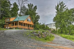una casa de madera con techo verde en un camino de grava en Charming Blakely Cabin with Porch and Valley Views!, en Blakely