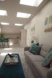 uma sala de estar com um sofá e uma mesa em The Loft, Bootham House - luxury city centre apartment with parking space em York