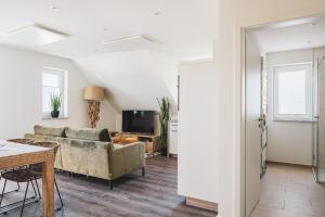 a living room with a couch and a table at Dünenquartier Apartment 30 in Zingst