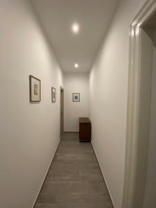 pasillo con paredes blancas y suelo de baldosa en Mario City Center Rooms, en Rijeka