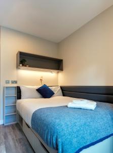 a bedroom with a large bed with a blue blanket at The Westwood Summer Accommodation in Galway