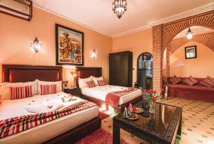 a hotel room with two beds and a couch at Riad Mabrouk in Marrakesh