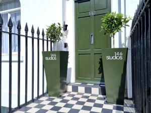 
a green and white fence with a blue door at 146 Studios in London
