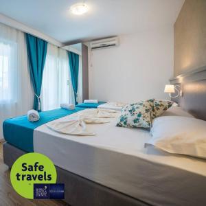 duże łóżko w pokoju z niebieskimi zasłonami w obiekcie Guest House S-Lux w Petrovacu na Moru