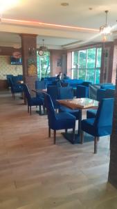 a restaurant with blue chairs and tables in a room at Buta Hotel Lerik in Lerik
