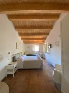 1 dormitorio con cama y techo de madera en La Visciola - Country House del Conero, en Sirolo