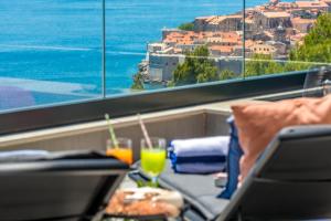a table with a laptop and two glasses of juice at Skywalker Royal in Dubrovnik
