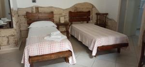a bedroom with two beds and a table and chairs at Otium Salento in Cutrofiano