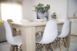 een eetkamer met een tafel en witte stoelen bij Isla Canela Sea & Sun Golf - Ayamonte in Ayamonte