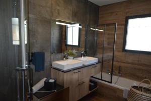 a bathroom with two sinks and a shower and a tub at Les villas du Golf Mougins in Mougins