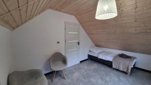 - une chambre avec un lit, deux chaises et une lampe dans l'établissement Przystań pod Witoszą, à Staniszów