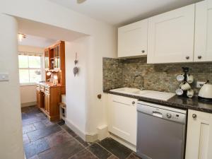 uma cozinha com armários brancos e um lavatório em Shepherd's Lodge em Richmond
