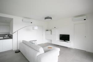 Biały salon z białą kanapą i telewizorem w obiekcie Fabula Home Rental - Trivia Resort w mieście Solto Collina