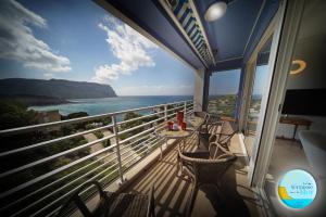 Un balcón con sillas y mesas y vistas al océano. en UNE TERRASSE SUR LA MER 3 pers 2 chambres VUE MER, en Cassis