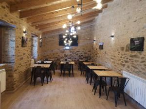 un restaurante con mesas de madera y sillas en una habitación en Casa Rural Camino Real, en Melide