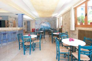 a restaurant with tables and chairs in a room at Hotel Korakakis Beach in Finikounta