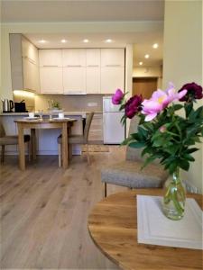 a kitchen with a vase of flowers on a table at Beautiful Apartment in the heart of Birstonas in Birštonas
