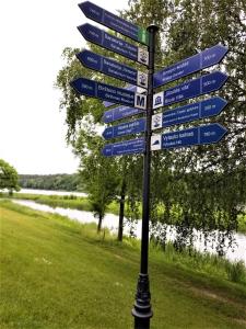 a street sign with blue signs on a pole at Beautiful Apartment in the heart of Birstonas in Birštonas