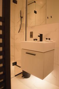 uma casa de banho branca com um lavatório e um chuveiro em The Loft, Bootham House - luxury city centre apartment with parking space em York