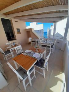 una sala da pranzo con tavoli e sedie e un balcone di B&B Fiore a Gallipoli