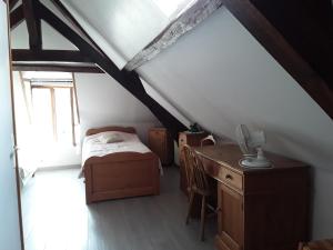 a bedroom with a bed and a desk in a attic at Maison( Clesanie ) in Serquigny