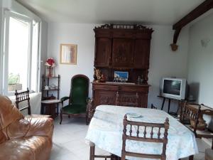 - un salon avec une table et une télévision dans l'établissement Maison( Clesanie ), 
