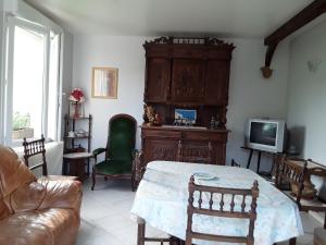 a living room with a table and a tv at Maison( Clesanie ) in Serquigny