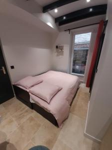 a small bedroom with a bed and a window at la studette du théâtre in Boulogne-Billancourt