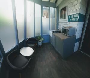 a small kitchen with a table and a microwave at Sandy Toes Accommodation in Par